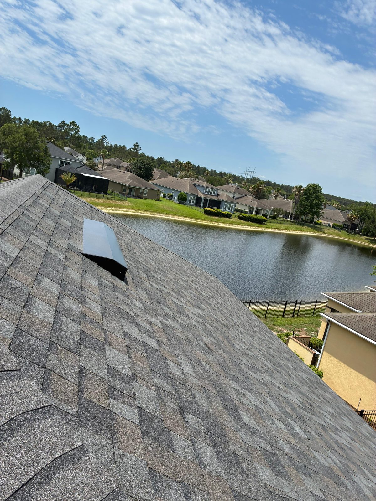 Completed residential asphalt shingle roof replacement in a Florida neighborhood